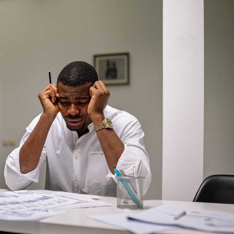 Focused professionals discussing plans over blueprints in a modern office