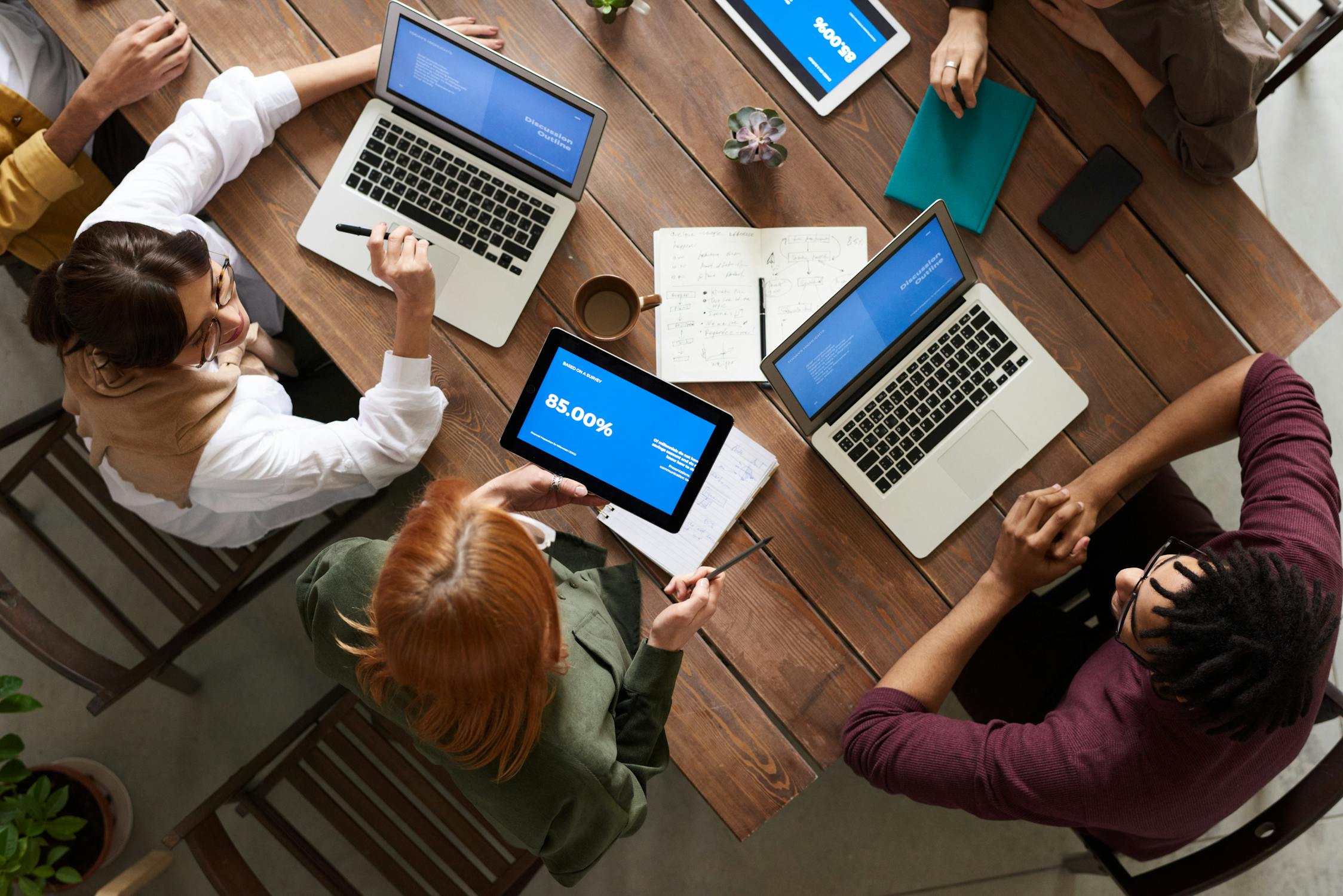 A business team discussing analytics on a laptop in a bright office