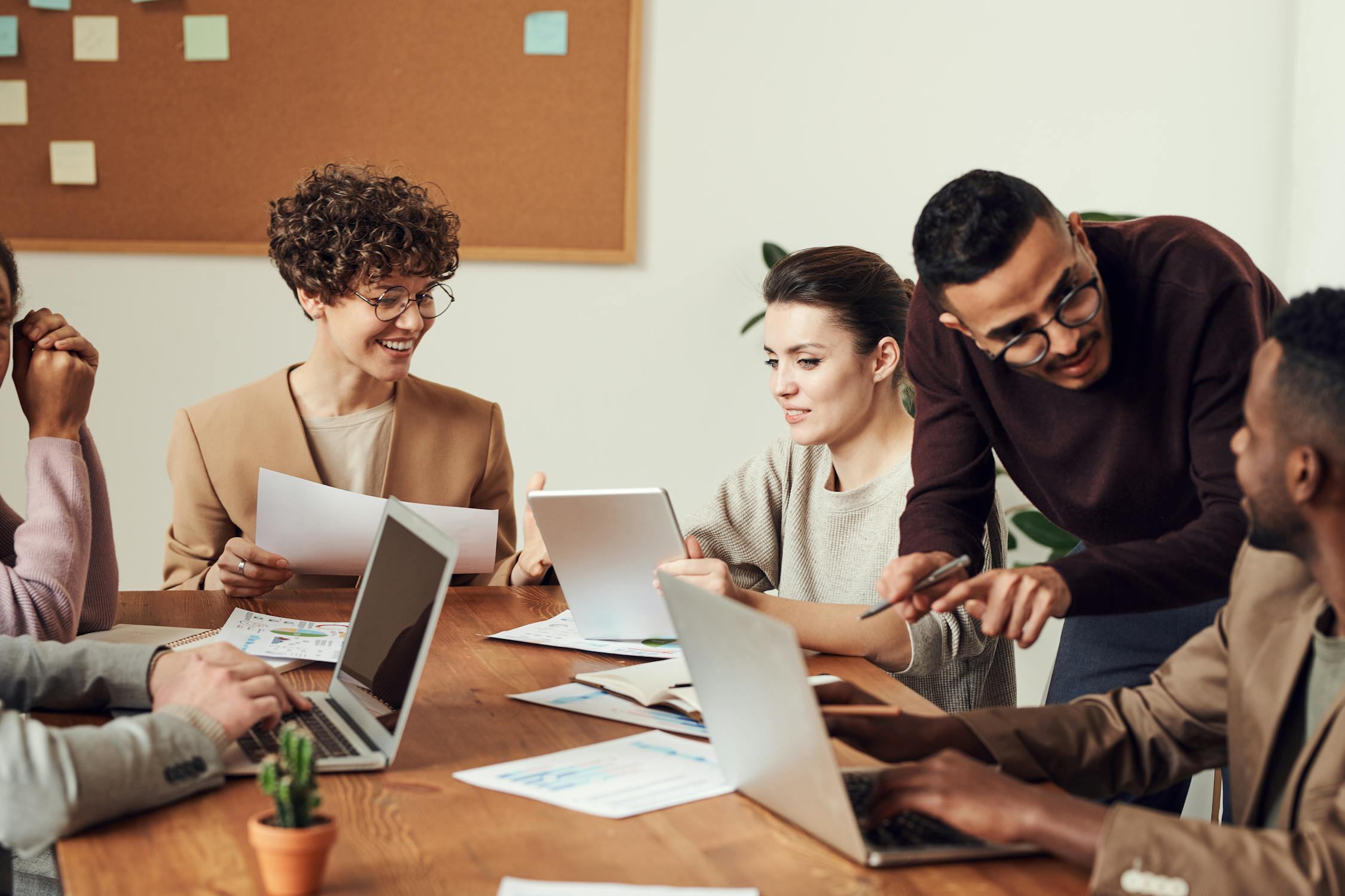 A team of business professionals discussing analytics on a tablet in a modern office